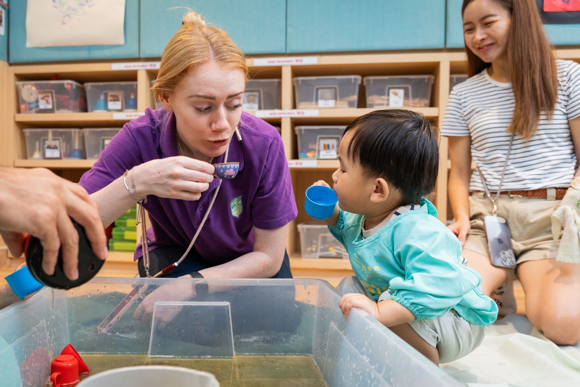 Native English teacher enjoying pretend tea time with a playgroup student