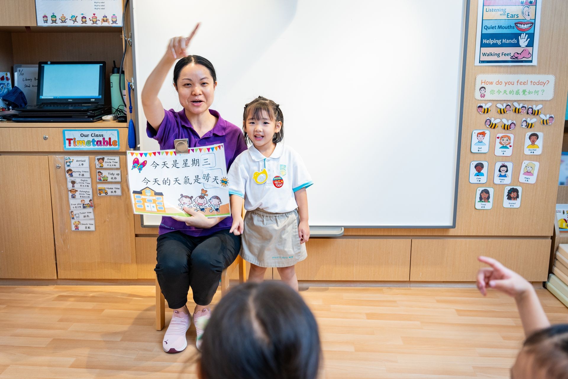  Teacher guiding a young girl through a Chinese picture book in the classroom