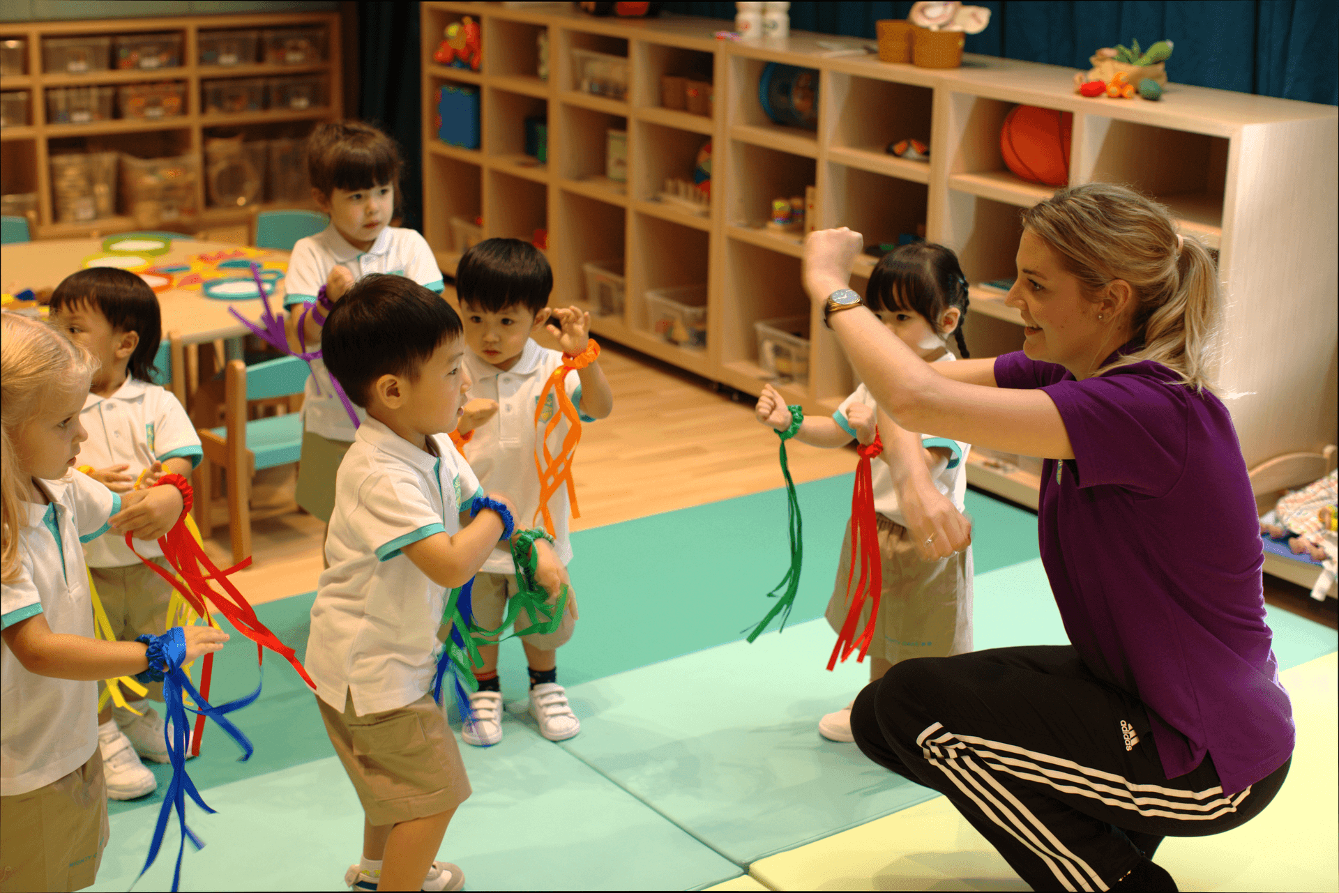 Teachers playing with children using music scarves