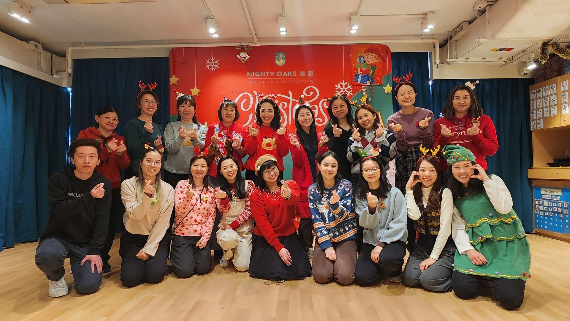 Mighty Oaks teaching staff smiling together at the Christmas party, dressed in festive attire